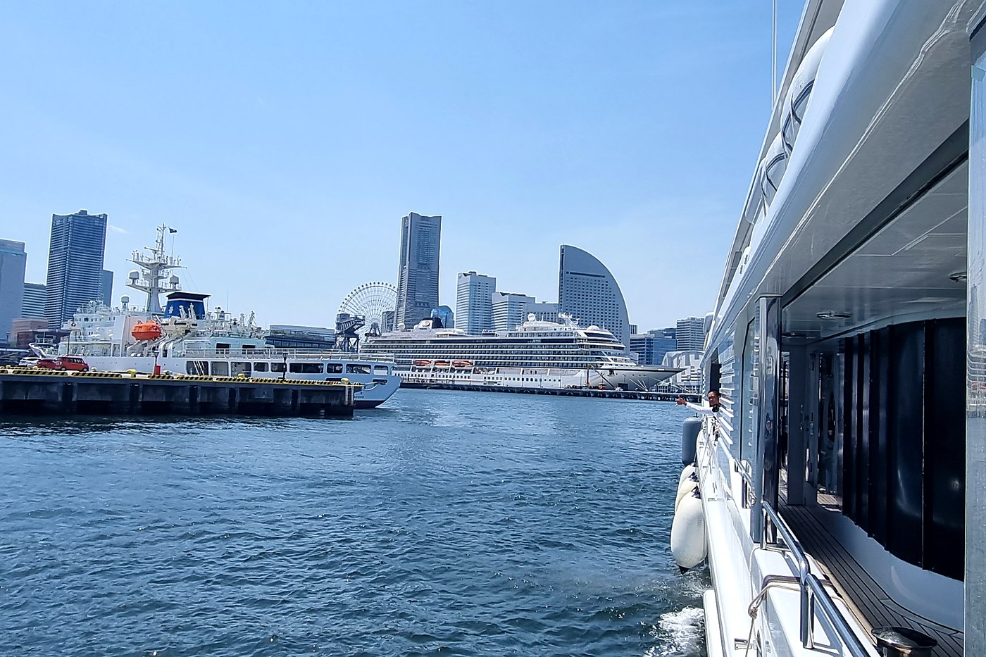 Superyacht side deck with a port city skyline in the background