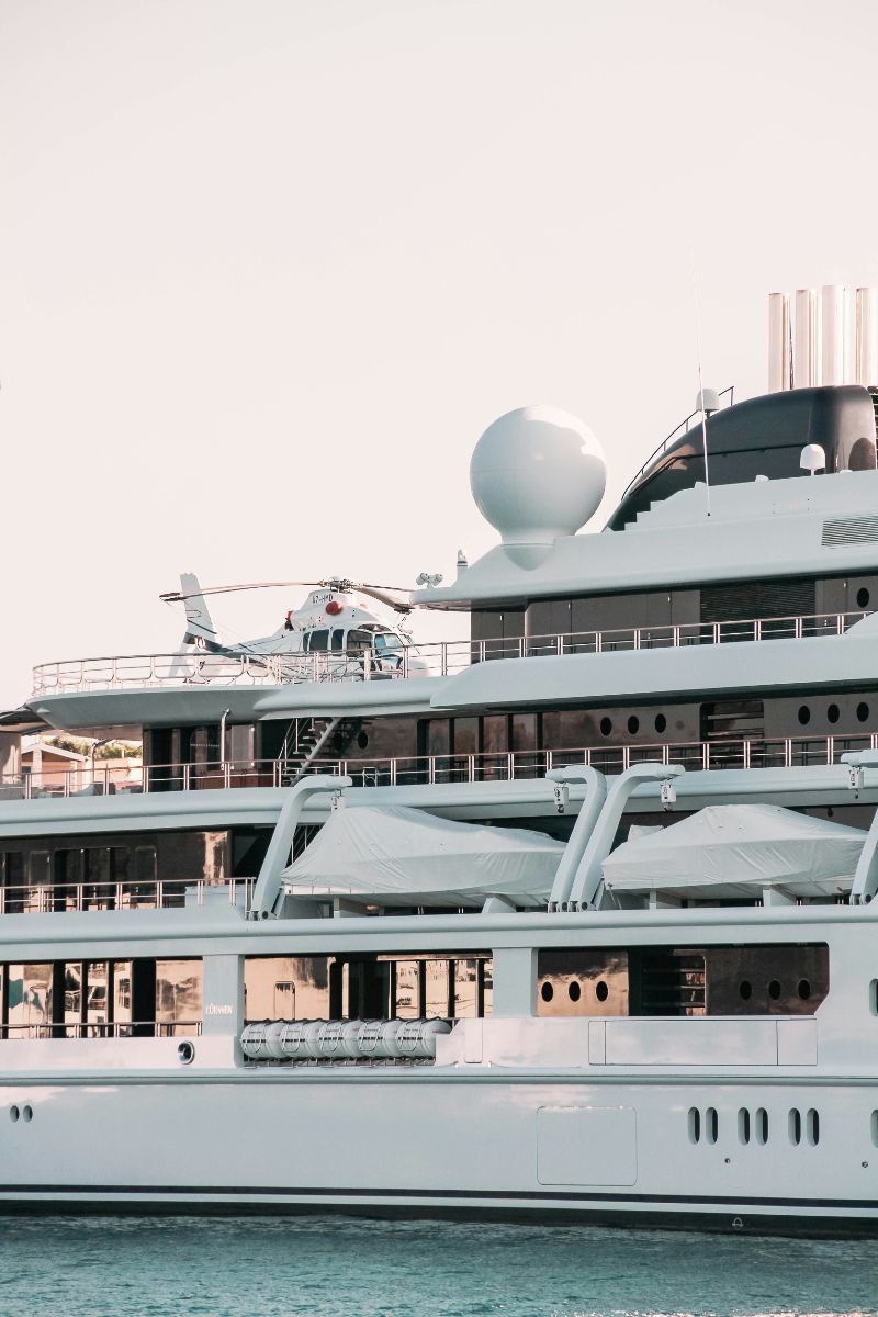 Lürssen superyacht with helicopter on deck, moored beside the town