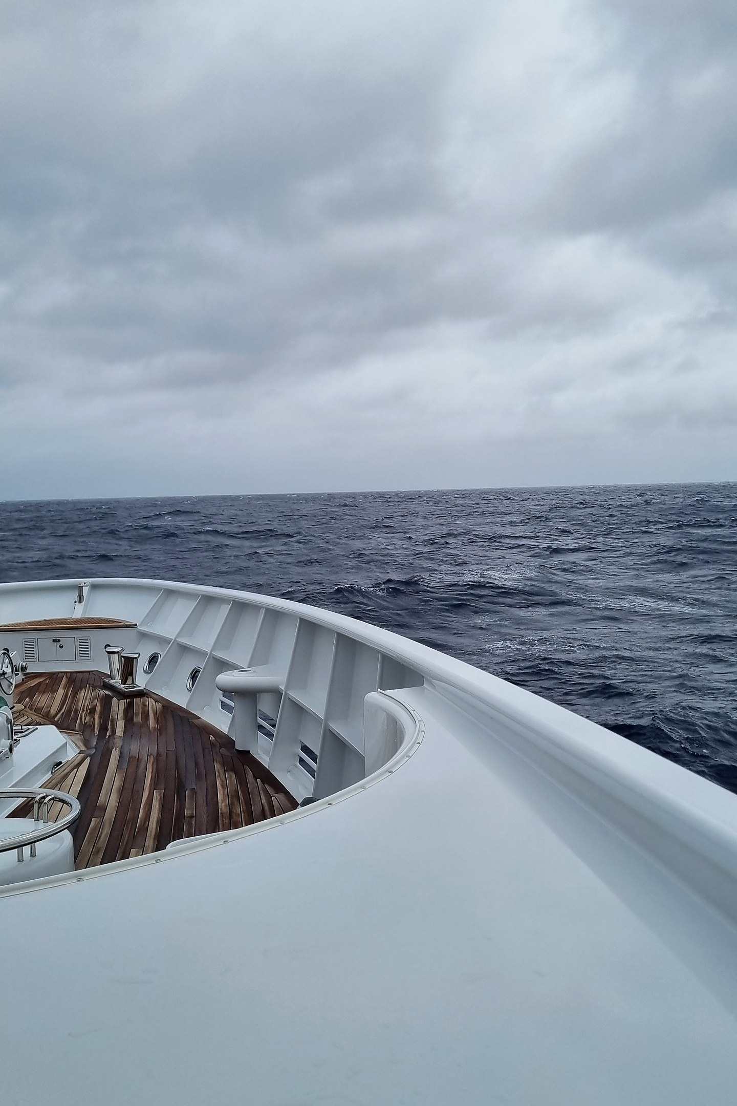 Bow of a superyacht curving through open water